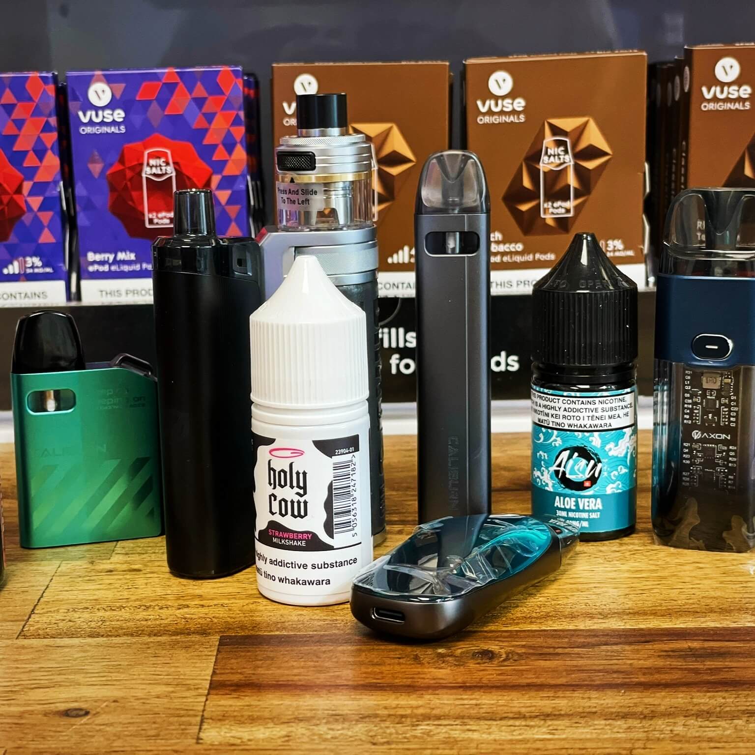 various vape pods and mods and two bottles of eliquid